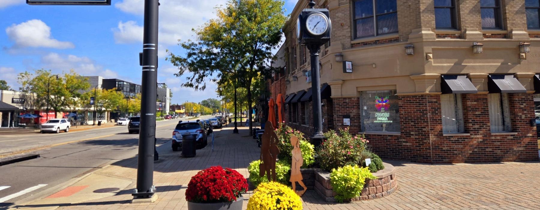 a clock on a pole next to a street sign